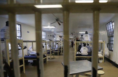 Inmates sit on their bunks in an overcrowded dormitory at Tutwiler Prison for Women in Wetumpka, Ala., Thursday March 31, 2016, as Gov. Robert Bentley, other officials and the media tour the facility. The prison, like every state prison, is overcrowded, with 945 inmates in a facility designed to hold 545. Gov. Robert Bentley is proposing issuing an $800 million bond to build four new facilities, one women's prison and three men's facilities, which would reduce replicated services, save money for the department and provide more space for training and rehabilitative services. (Governor's Office, Jamie Martin)