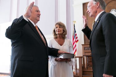 Alabama Gov. Robert Bentley, right, delivers the oath of office to Mike Hill, superintendent of the Alabama Banking Department in the Old House Chamber at the state Capitol in Montgomery, Tuesday, July 5, 2016, in Montgomery. Superintendent Hill's wife Carol holds the Bible. (Governor's Office, Sydney A. Foster)