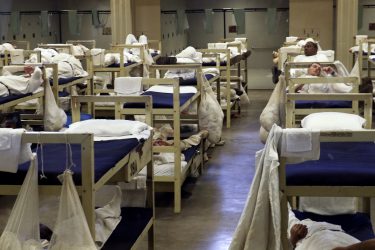 Inmates in a dorm lie in bed as Governor Robert Bentley tours Limestone Correctional Facility with Department of Corrections Commissioner Jeff Dunn and others in Harvest, Ala. on Monday, April 4, 2016. Limestone Correctional Facility, like all of Alabama's prisons is overcrowded. The facility was originally designed for 1,300 inmates, but now houses 2,237 men. Dayroom areas now have double-stacked beds, taking up space for inmate re-entry programs and other educational opportunities for inmates. (Governor's Office, Jamie Martin)